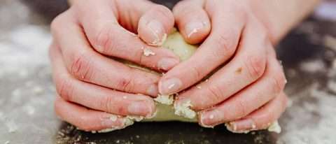 corso pizzaiolo torino: mani che impastano la farina